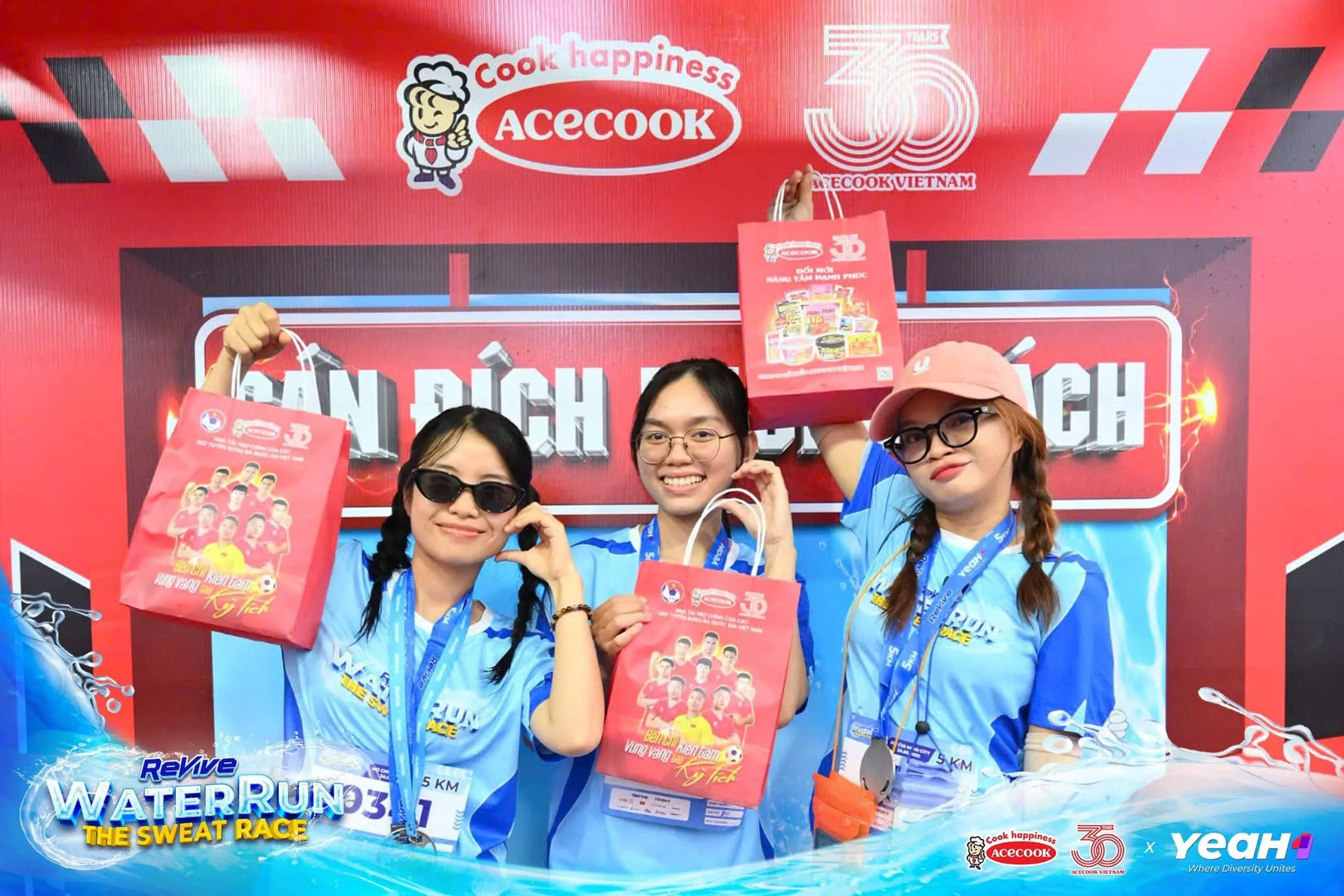 Các bạn trẻ vui vẻ check-in tại khu vực trạm tiếp sức, tay cầm túi quà từ Acecook, ánh mắt rạng rỡ, tạo nên không khí sôi động và đầy kết nối.